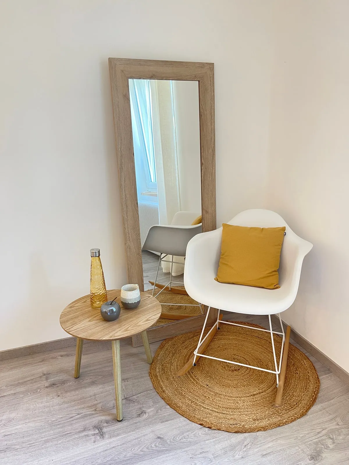 Coin détente avec miroir, fauteuil blanc et tapis en jute